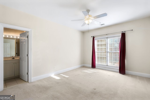 carpeted empty room featuring ceiling fan and sink