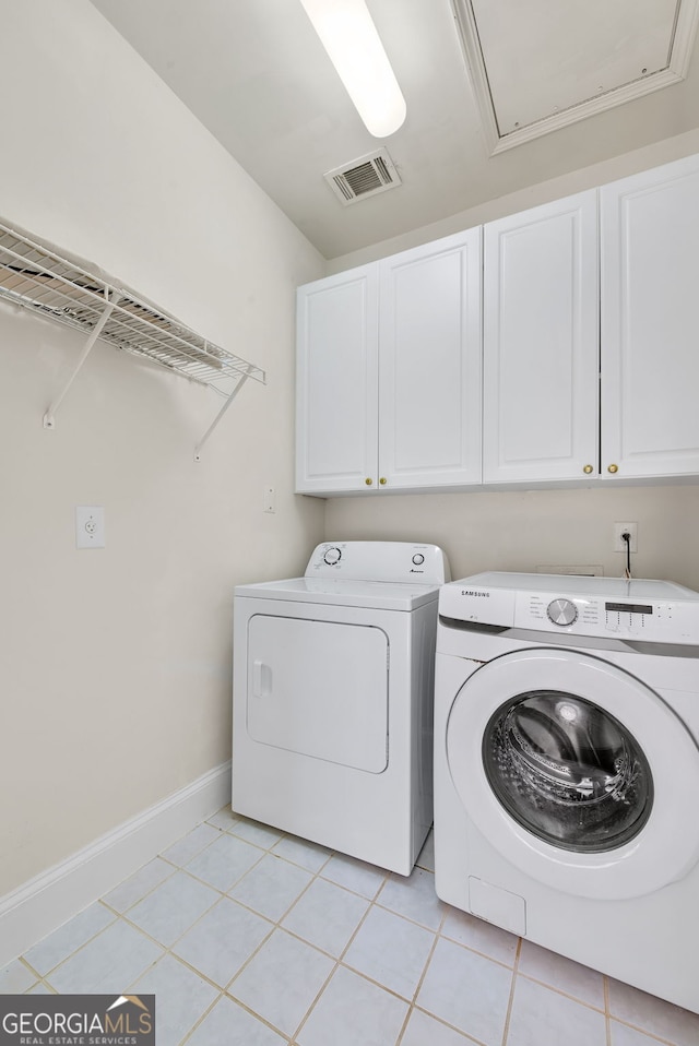 washroom with cabinets, light tile patterned flooring, and washing machine and clothes dryer