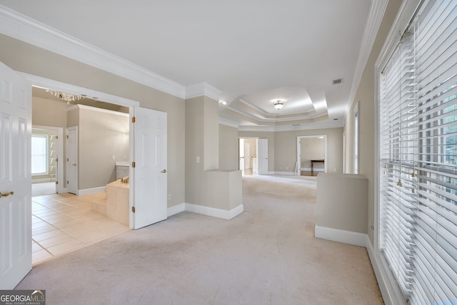 hall with light colored carpet, crown molding, and a tray ceiling