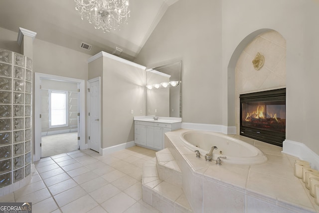 bathroom with vanity, tile patterned floors, vaulted ceiling, tiled tub, and a chandelier