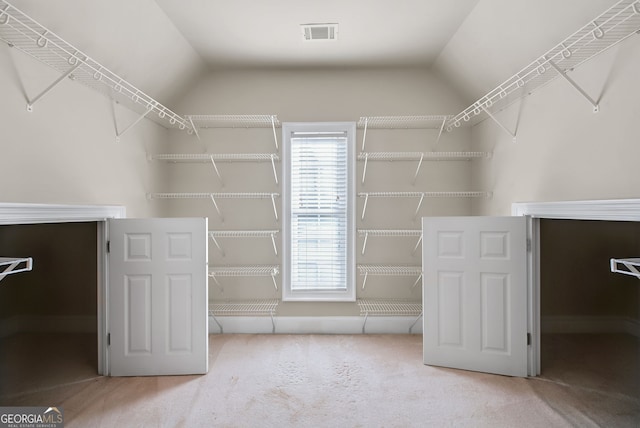 spacious closet featuring carpet and vaulted ceiling