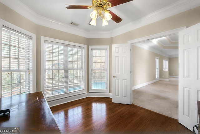 empty room featuring dark colored carpet, ceiling fan, and crown molding