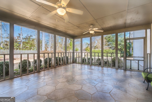 unfurnished sunroom with ceiling fan