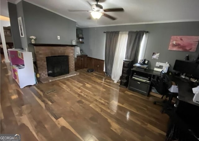 office space with ornamental molding, ceiling fan, wood-type flooring, a fireplace, and wood walls