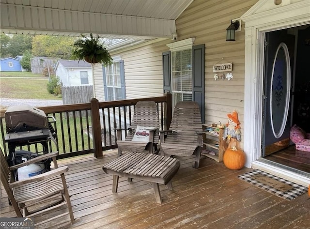 wooden terrace with covered porch and a grill