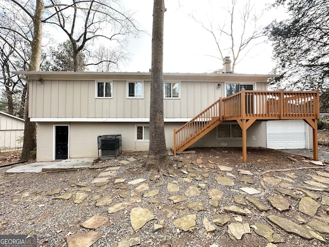 back of house featuring central AC unit and a deck