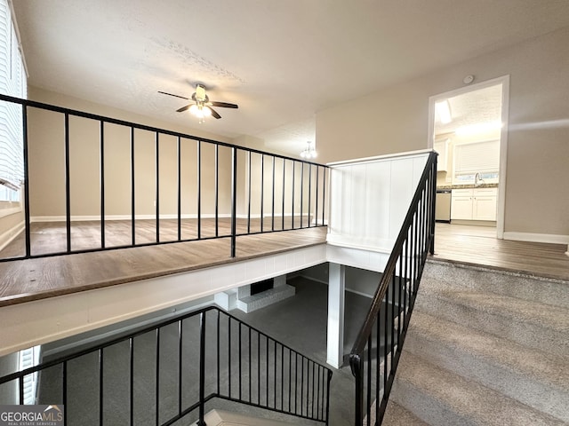 stairway featuring ceiling fan