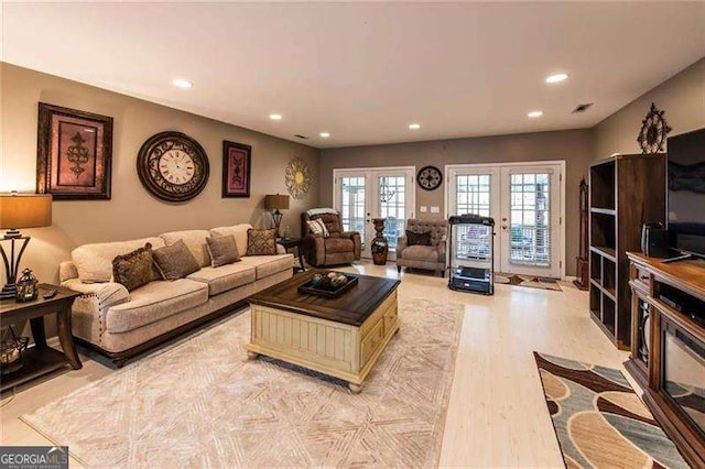 living room featuring french doors and light hardwood / wood-style flooring