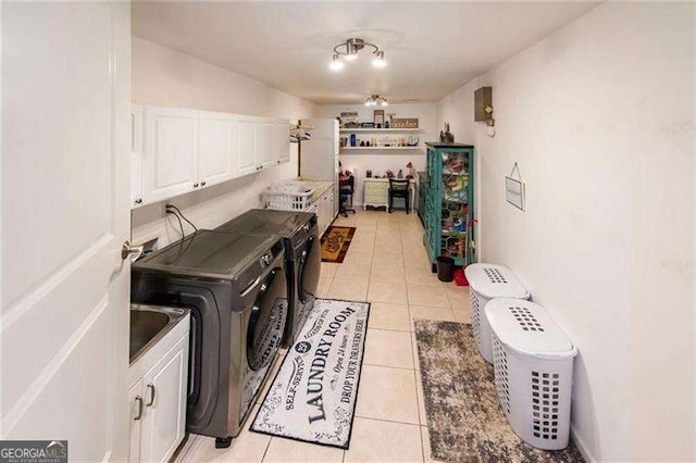 laundry area featuring cabinets, light tile patterned floors, washer and clothes dryer, and ceiling fan