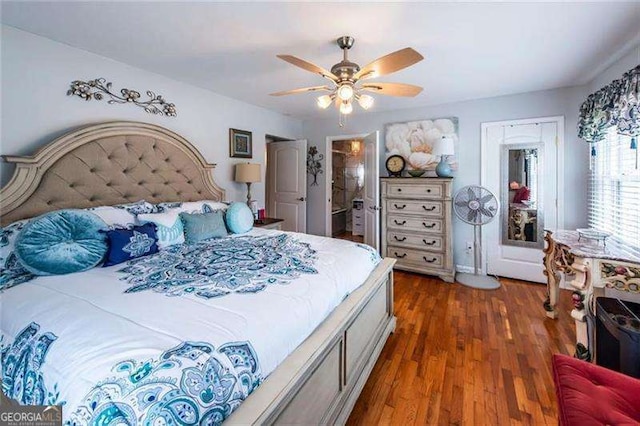 bedroom with ceiling fan, dark hardwood / wood-style flooring, and connected bathroom