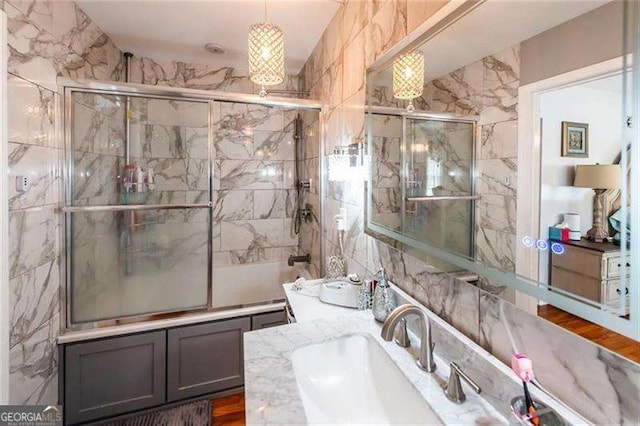 bathroom with shower / bath combination with glass door and vanity