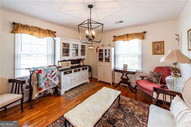 living room with dark hardwood / wood-style flooring and a notable chandelier