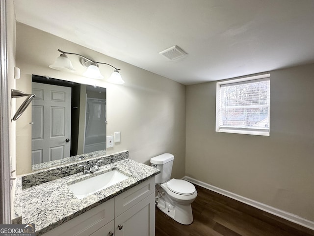 bathroom with hardwood / wood-style floors, vanity, and toilet