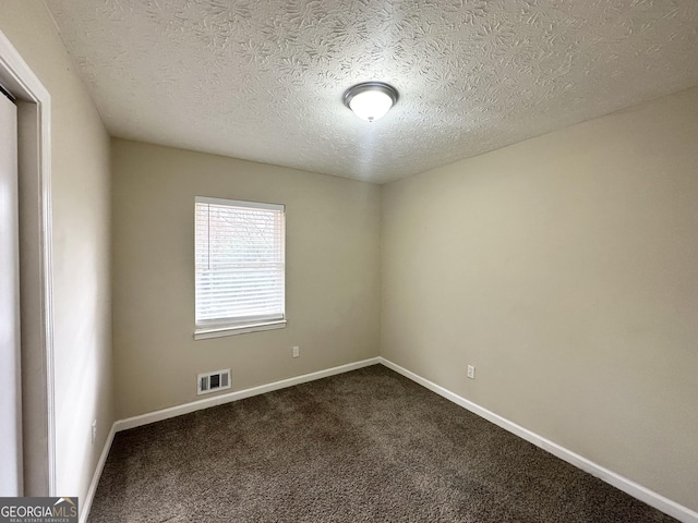 carpeted spare room featuring a textured ceiling