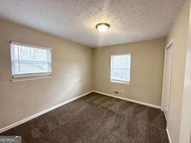 carpeted spare room with a textured ceiling