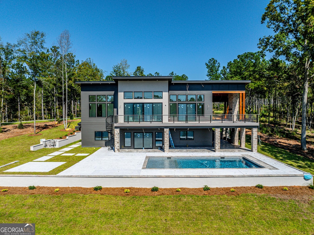 409 White Oak Cv, Milledgeville, GA 31061 - back of house featuring a balcony, a patio area, and a lawn