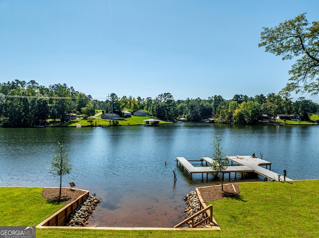 view of dock with a water view and a yard