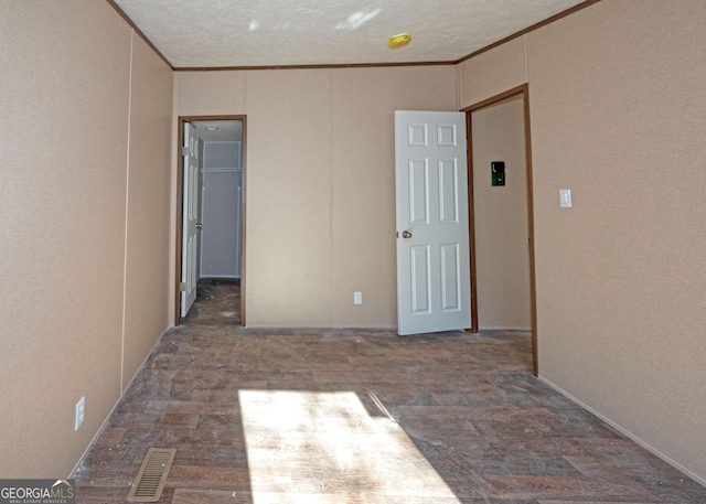 spare room with a textured ceiling and crown molding