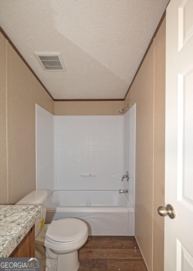 full bathroom featuring vanity, wood-type flooring, a textured ceiling, and crown molding