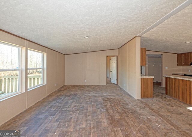 unfurnished living room featuring hardwood / wood-style floors, a textured ceiling, and crown molding