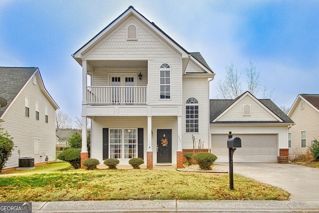 front facade featuring cooling unit, a balcony, and a garage