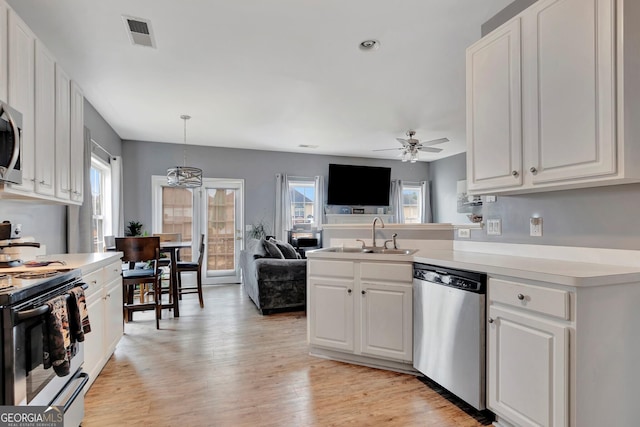 kitchen featuring ceiling fan with notable chandelier, white cabinetry, and stainless steel appliances