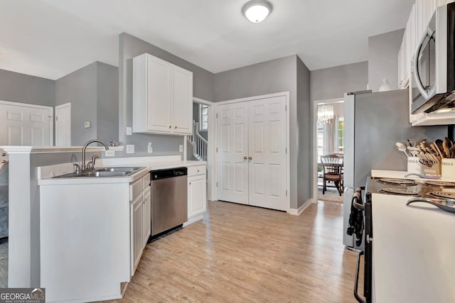 kitchen with white cabinets, stainless steel appliances, light hardwood / wood-style flooring, and sink