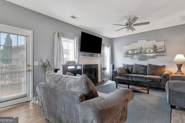 living room with light hardwood / wood-style flooring and ceiling fan