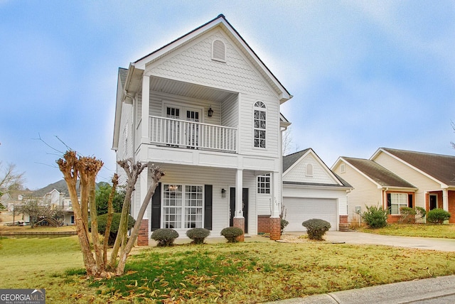 view of front of house featuring a balcony, a front yard, and a garage