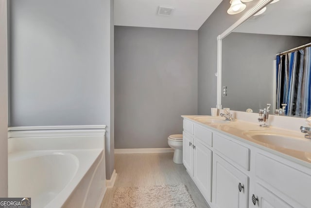 bathroom featuring vanity, toilet, wood-type flooring, and a bath