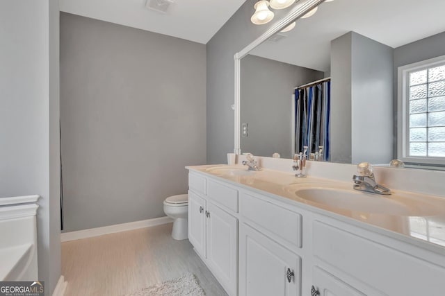 bathroom featuring wood-type flooring, vanity, and toilet