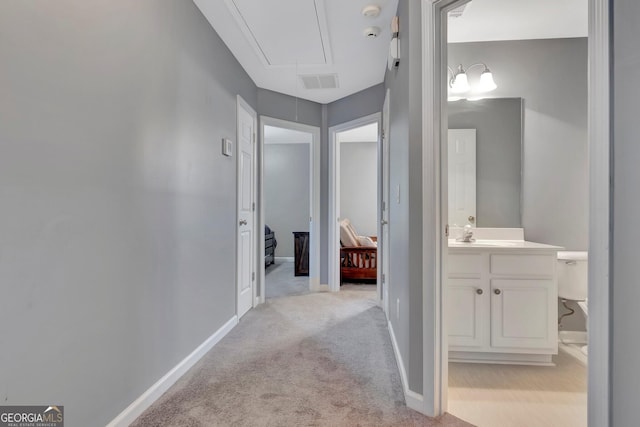 hallway with light carpet and sink