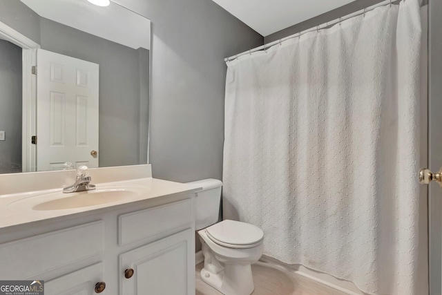 bathroom featuring a shower with shower curtain, vanity, and toilet