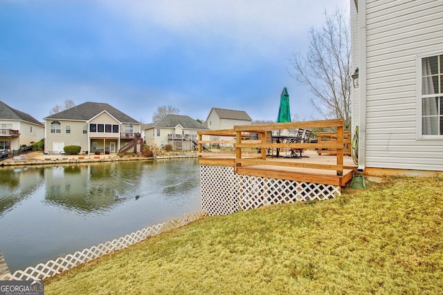 view of dock with a deck with water view and a yard