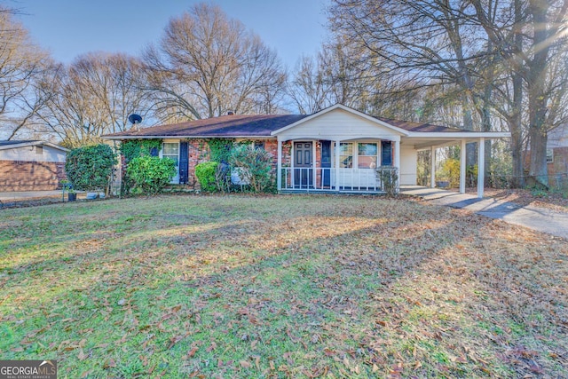 ranch-style house featuring covered porch, a carport, and a front yard