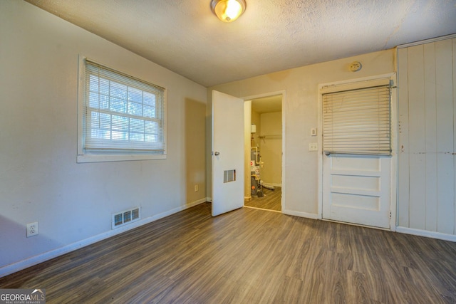 unfurnished bedroom featuring a textured ceiling and dark wood-type flooring