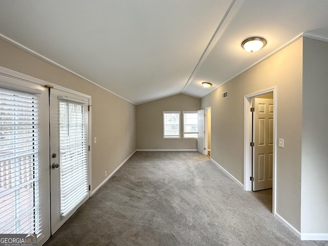 carpeted spare room featuring lofted ceiling and a wealth of natural light