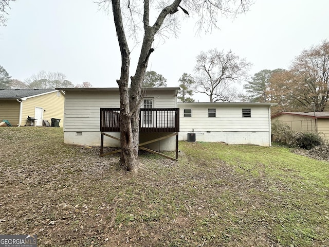 back of property with central AC, a yard, and a deck