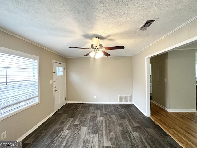 interior space with ceiling fan, dark hardwood / wood-style flooring, a textured ceiling, and ornamental molding