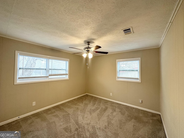 carpeted spare room featuring a textured ceiling, ceiling fan, and ornamental molding