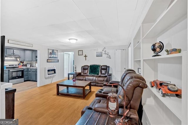 living room featuring heating unit, built in features, and light hardwood / wood-style flooring