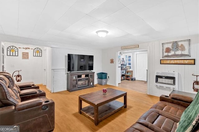 living room with heating unit and light hardwood / wood-style flooring