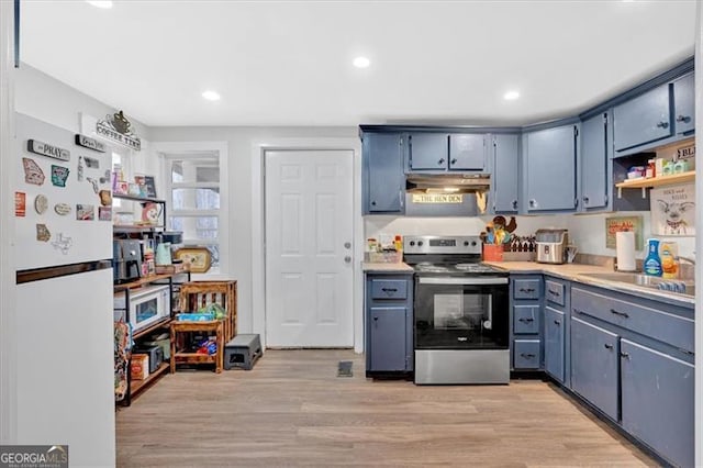 kitchen featuring stainless steel range with electric cooktop, white refrigerator, sink, light hardwood / wood-style flooring, and blue cabinetry