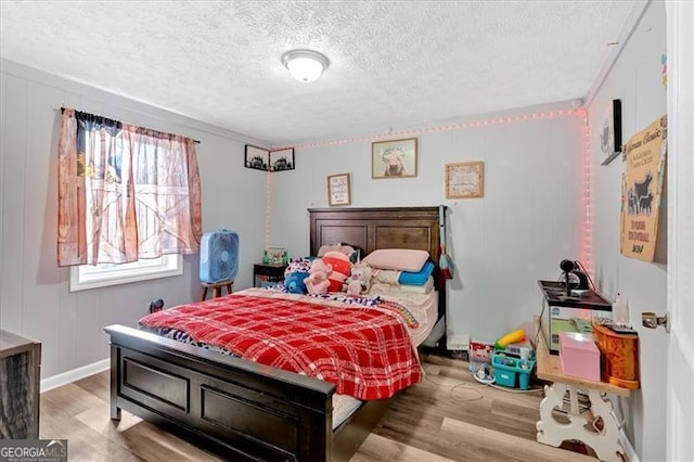 bedroom with a textured ceiling and light wood-type flooring