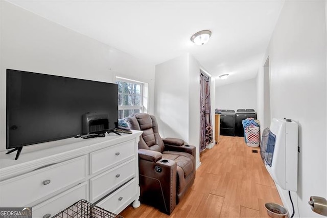 living area featuring light wood-type flooring and heating unit