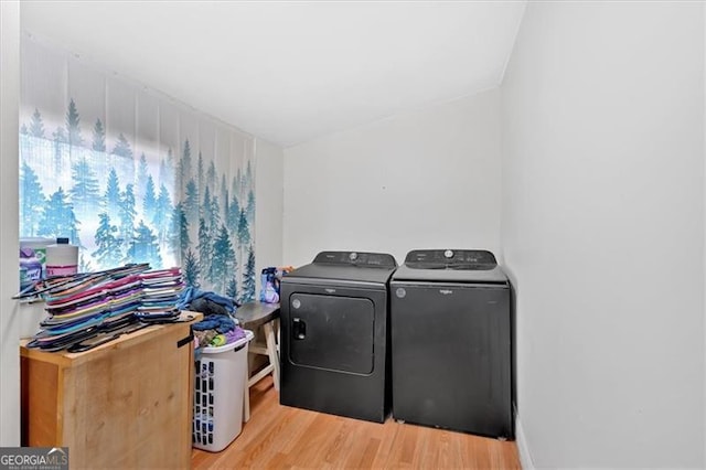 clothes washing area with separate washer and dryer and light hardwood / wood-style flooring