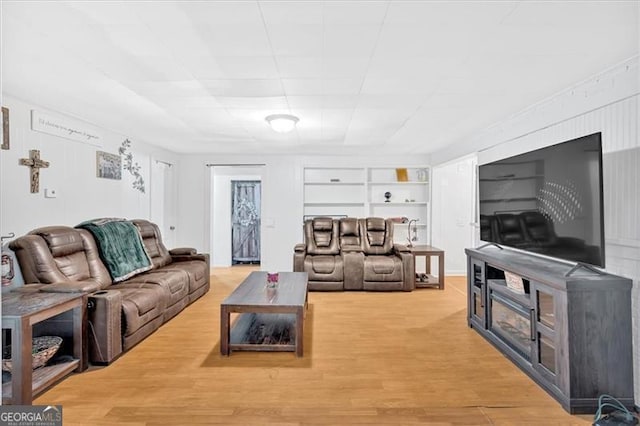 living room featuring built in shelves and hardwood / wood-style flooring