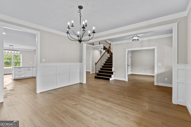 unfurnished dining area featuring an inviting chandelier, light hardwood / wood-style floors, and ornamental molding