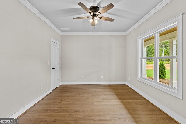 empty room featuring ceiling fan, light wood-type flooring, and crown molding