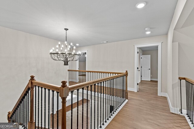 hallway featuring a chandelier and light wood-type flooring